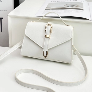 White minimalist crossbody square bag with gold buckle on a stylish white pedestal