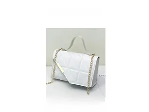 Detail of white quilted handbag featuring elegant diamond stitching and gold chain strap
