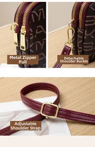 Detailed view of gold-tone zippers and detachable strap hooks on burgundy textured leather bag