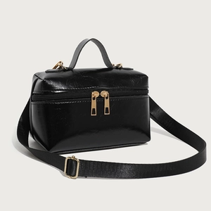 Glossy black oil wax leather handbag with gold hardware and wide shoulder strap
