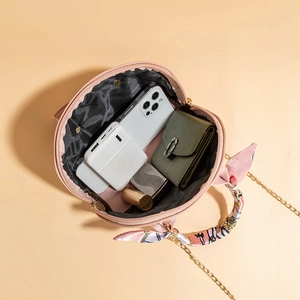 Pink shell handbag with chain strap, floral silk scarf, and interior item storage