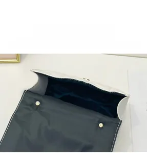 Detailed interior of white quilted handbag showing magnetic clasp and black lining