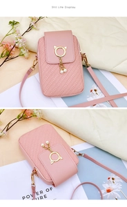 Détail du sac de téléphone rose avec texture tissée et breloque perle oreilles de chat
