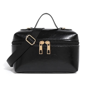 Black oil wax leather rectangle handbag with top handle and golden zippers on white background