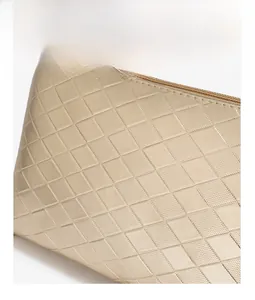 Macro shot of champagne gold quilted PU leather with fine stitching and zipper detail