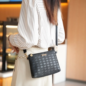 Classic black quilted crossbody bag with gold hardware worn by a model in a cozy setting