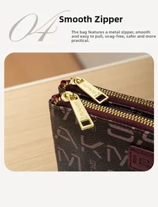 Close-up of dual gold zippers and monogram pattern on dark brown leather handbag