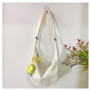 Détail du sac bandoulière en toile crème avec fleur jaune et sangle réglable