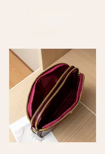 Detail view of the multi-layer storage compartments and gold zippers of this retro bag