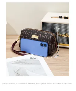 Vintage patterned clutch bag with wrist strap, 20x8x11cm dimensions shown on table
