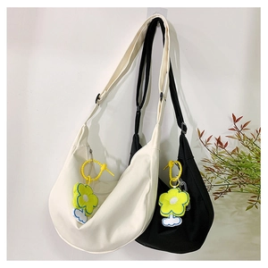 Détail de sacs bandoulière demi-lune en toile avec bandoulières et breloques fleurs