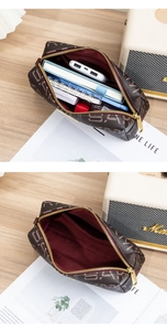 Macro view of vintage brown monogrammed clutch bag showing spacious interior with liner
