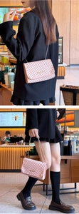 Detailed view of pink flap shoulder bag with geometric monogram and metal chain strap