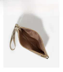 Detail showing inner compartment of champagne gold quilted clutch with zipper closure