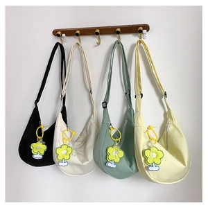 Vue détaillée de quatre sacs demi-lune en toile avec breloques de tournesol au mur