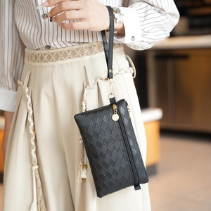 Elegante borsa a busta nera intrecciata con cerniera dorata e cinturino da polso raffinato