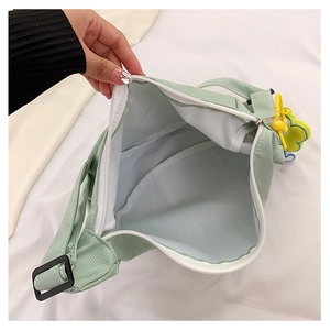 Vue détaillée du sac en toile vert clair avec doublure blanche et espace intérieur