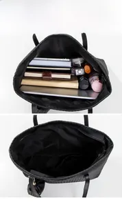 Detail of black woven tote bag showing spacious interior with zipper pocket and lining