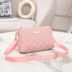 Close-up of pink quilted crossbody bag with golden zipper and textured PU leather