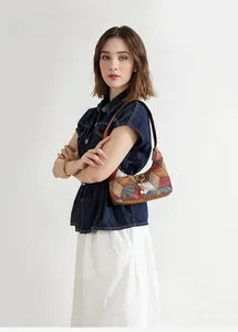 Detailed side view of multi-color patchwork hobo bag with pearl charm on denim jacket