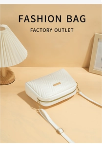 Detailed view of beige chevron quilted crossbody bag with gold hardware on a warm background