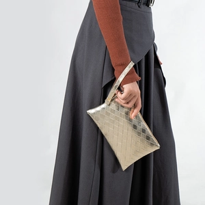 Mini gold clutch bag featuring woven checkered pattern and metallic faux leather texture