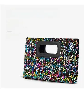 Detail of a rectangular sequined handbag featuring colorful patterns and black leather trim