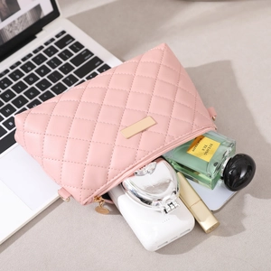 Pink quilted organizer bag with gold hardware showing storage for cosmetics and tech