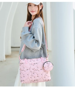 Close-up of pink tote bag featuring intricate floral embroidery and small round coin purse