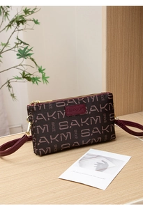 Detail of vintage brown crossbody bag with letter print and gold zipper hardware