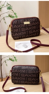 Close-up of triple-zipper structure and vintage SAKM monogram print on cross-body bag