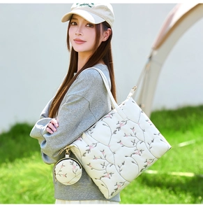 Detail of white tote bag with floral embroidery and matching round coin purse charm
