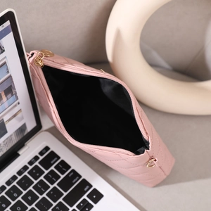 Pink quilted makeup bag interior view with gold hardware and black fabric lining