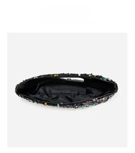 Interior view of colorful sequin handbag showing black fabric lining and storage pocket