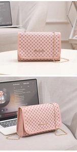 Detail view of pink flap bag with geometric patterns and golden metal chain strap