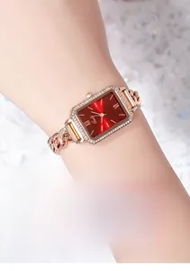 Dettaglio dell'orologio rettangolare in oro rosa con quadrante rosso e lunetta in cristallo