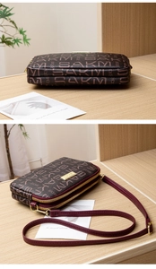 Close-up of small crossbody bag with letter prints, dual-zipper layers and metal logo