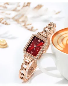 Dettaglio dell'orologio rettangolare in oro rosa con quadrante rosso e lunetta di cristalli