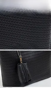 Detail of black woven tote bag with a detachable coin purse and gold hardware accents