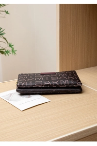 Detail view of double-zipper wallet with vintage pattern on a light wooden display