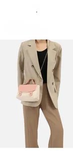 Straw crossbody bag with pink leather flap and gold chain strap on a model