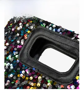 Macro view of sequin clutch bag detailing reinforced double stitching and leather trim