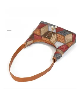 Detail of color-block underarm bag with pearl trim and dual detachable straps
