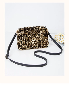 Detailed close-up of golden sequins on a luxury square shoulder bag with black strap