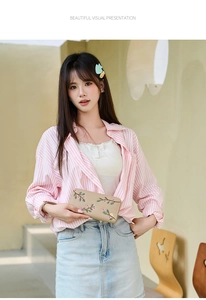 Outdoor shot of embroidered floral beige long wallet with pink buds and green leaves
