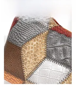 Macro detail of patchwork leather handbag with animal textures and zig-zag stitching