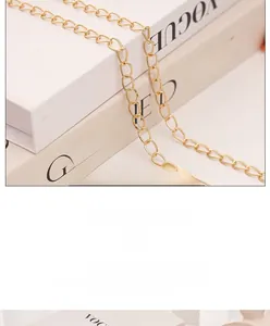 Detail eines hellgoldenen Metallkettenriemens mit flachen Gliedern für eine Handtasche