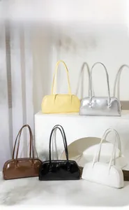 Présentation physique de cinq sacs baguette en cuir verni vintage en diverses couleurs