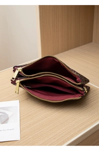 Detailed view of the three-layered interior and gold zippers on the printed crossbody bag