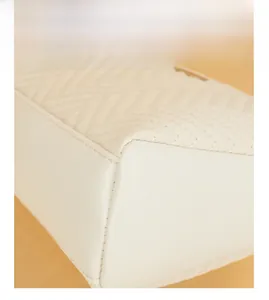 Detailed view of cream chevron quilted stitching and premium leather texture on crossbody bag